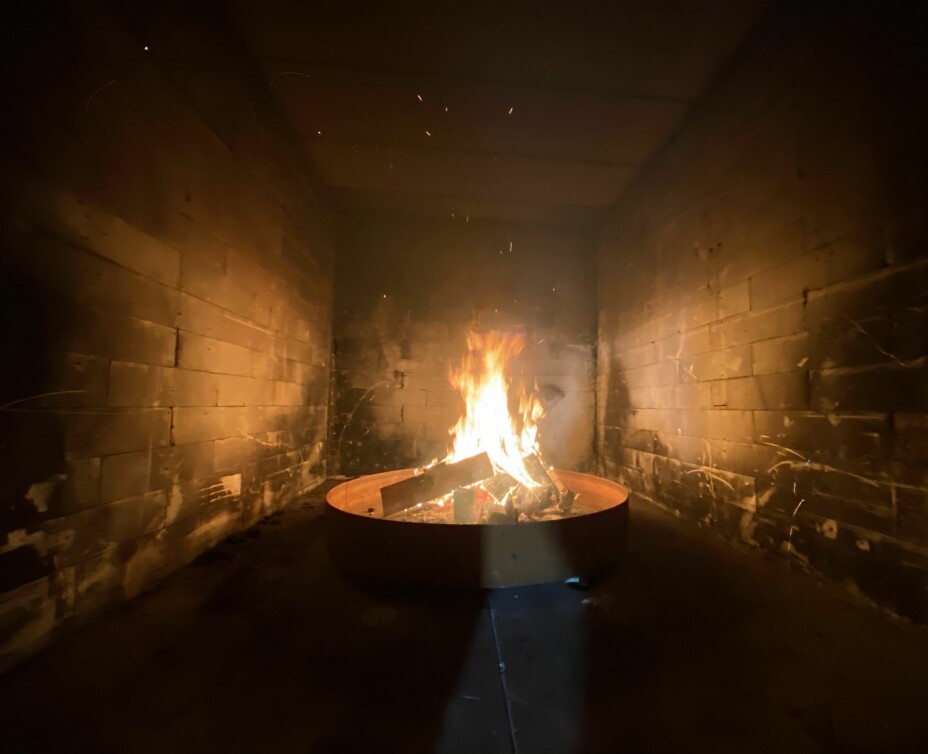 Bildet viser brannrommet med bål av påtente trepaller.