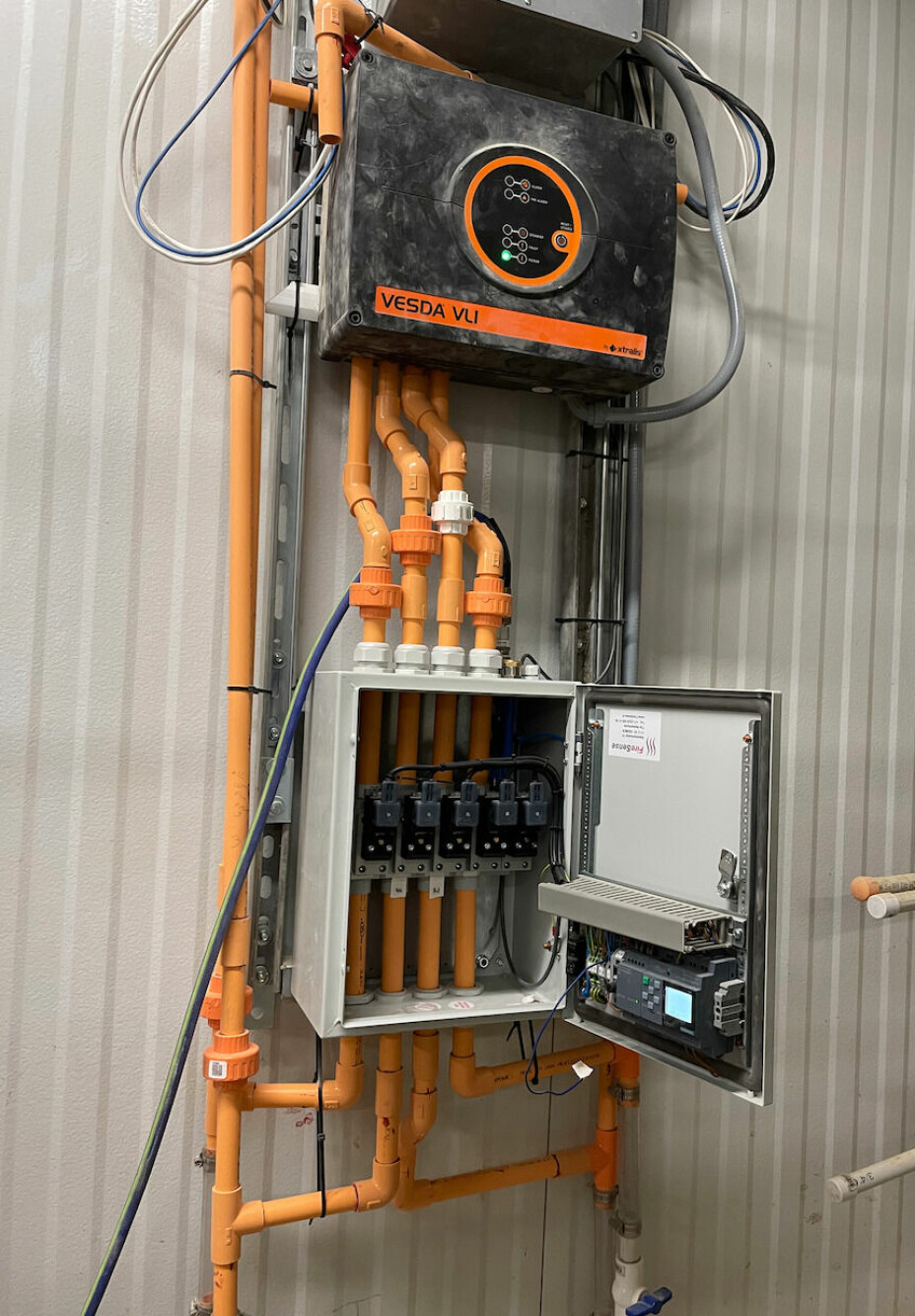 Honeywells VLI aspirerende røykdetektorsystem trekker luftprøver gjennom hull i lange løp av slitesterkt industrirør montert langs vegger og tak.
